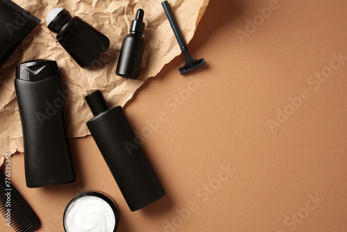 Flat lay composition with men's cosmetic products on craft paper on brown background. Beauty products for men's skin care, grooming. photo