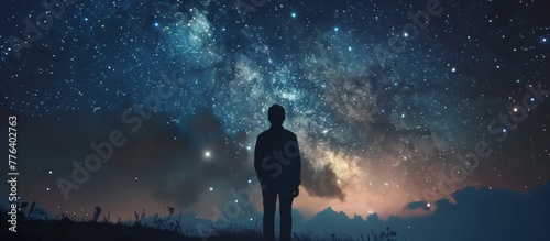 A man standing on a hill looking at the stars