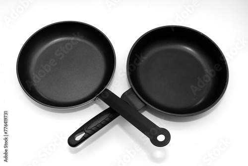 Empty black non stick stainless steel frying pans isolated on white  © Tatty