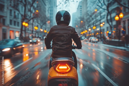 A motorcyclist rides smoothly on a rain-soaked street with city lights shining through the wet ambiance photo