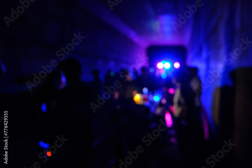 Underground disco party. Flashing lights and defocused silhouettes of people on a dance party