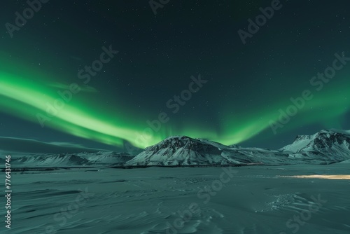 Scenic view of green auroral lights streaked at night against clear skies over snow-capped mountains © Aliaksandr Siamko