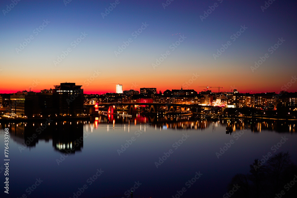 Scenic view of illuminated buildings against sky at sunset