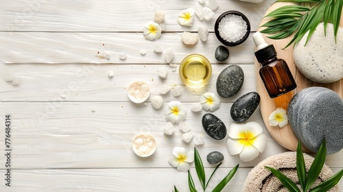 Beauty treatment items for spa procedures are arranged on a white wooden table, including massage stones, essential oils, and sea salt, with ample copy space available. photo