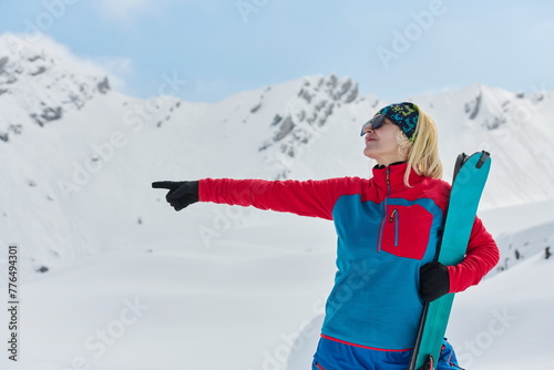 A professional woman skier rejoices after successfully climbing the snowy peaks of the Alps