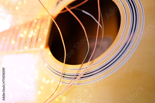 close-up wooden part of the instrument, changing strings on acoustic guitar, strings hanging freely, guitar tuning, replacing strings torn from energetic performance to play musical instruments photo