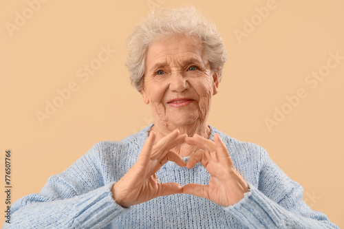 Senior woman making heart w...