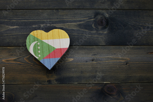 wooden heart with national flag of comoros on the wooden background.