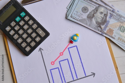 Canvas Print Top view image of rocket, money, calculator and graph on wooden table