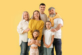 Big family hugging on yellow background