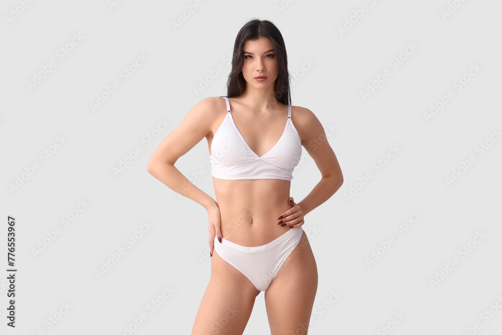 Pretty young woman in white underwear on blue background Pretty young woman in white underwear on blue background