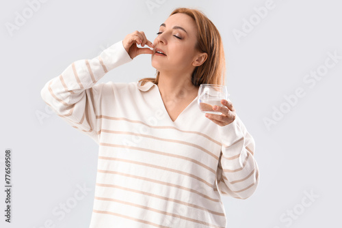Mature woman taking pill on...