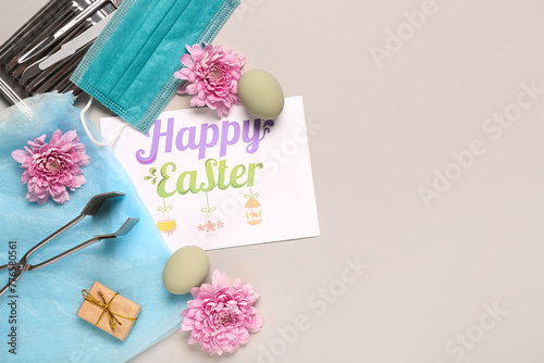 Composition with greeting card, surgeon's tools and Easter decor on grey background