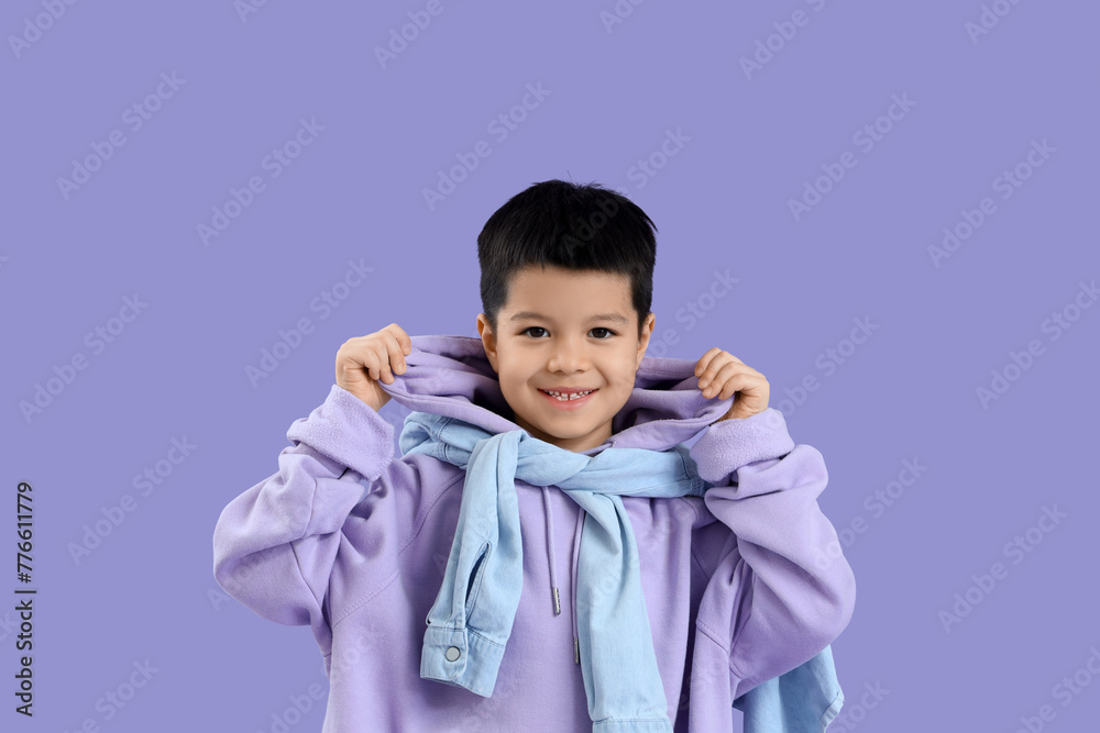Cute little Asian boy in adult clothes on lilac background Cute little Asian boy in adult clothes on lilac background