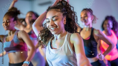Depict a spirited dance fitness class where young sportswomen immerse themselves in the rhythm and energy of the music, celebrating the joy of movement and the fusion of exercise and dance. photo