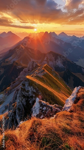 A panorama of a breathtaking sunset over a vast mountain range, showcasing the dramatic peaks bathed in warm light
