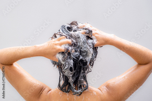 Beautiful woman's hand She was washing her hair and nourishing her scalp. Shampoo and conditioner	
