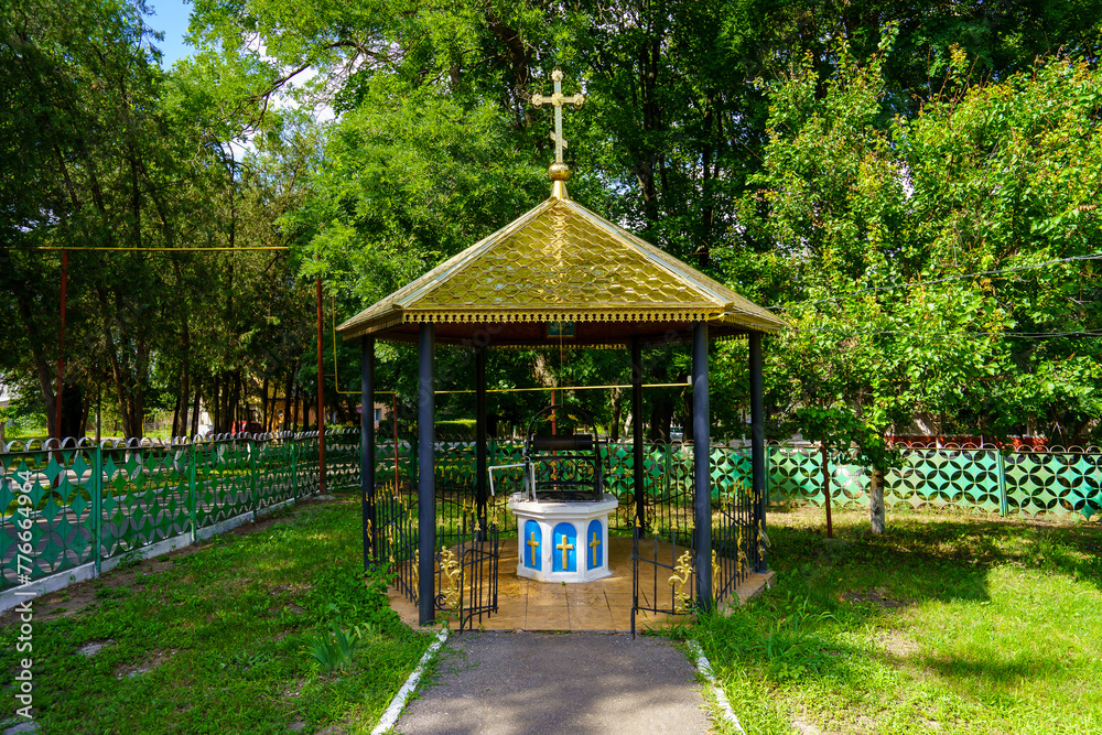 Naklejka premium A small gazebo with a cross on top sits in a park