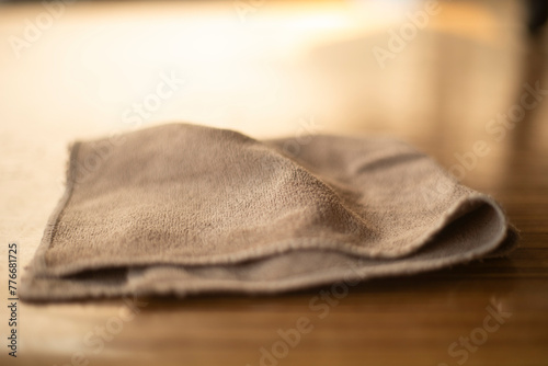 Close up of a linen napkin on a wooden table in a kitchen