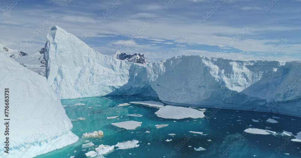 Tabular icebergs melting at rising sea aerial. Nobody nature, environment and landscapes of Antarctica ocean bay. Large ice fjord at blue arctic seascape. Affected by climate change and global warming