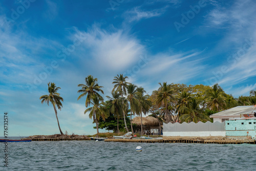 Boat on the seashore and stone spur. San Bernardo, Bolivar, Colombia.  photo