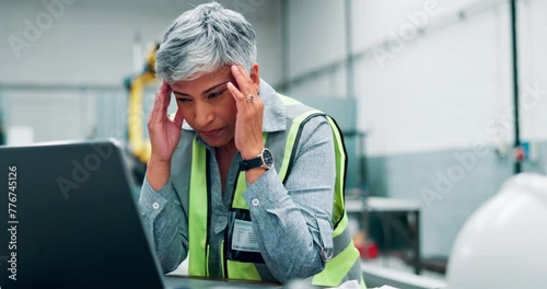 Headache, stress and woman with laptop for architect, contractor or engineer in industrial building. Migraine, mature person and technology for burnout, exhausted or overwhelmed with project deadline photo