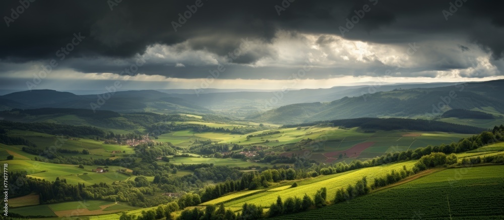 Glimpse over a valley showcasing sparse trees and rolling hills under the sky's vast expanse