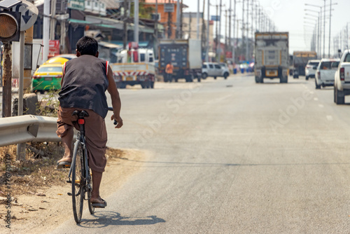 A man rides a road bike on a highway in the city center  Bangkok  Thailand