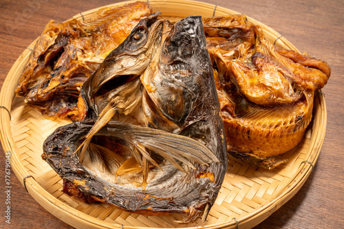 Dried fish in basket on wooden table background.