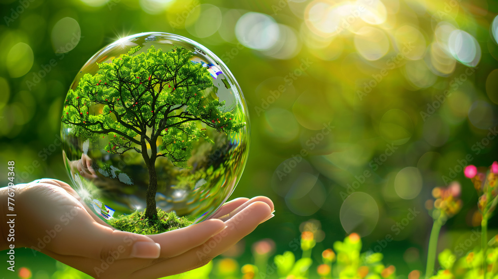 hand holding a crystal ball containing a tree in the flower garden,earth day concept  ecology  ecological balance