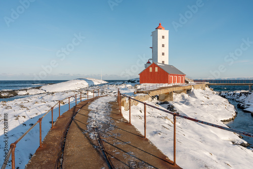 Kjolnes Lighthouse by the Barents Sea on a sunny winter day in March, Berlevåg Norway photo