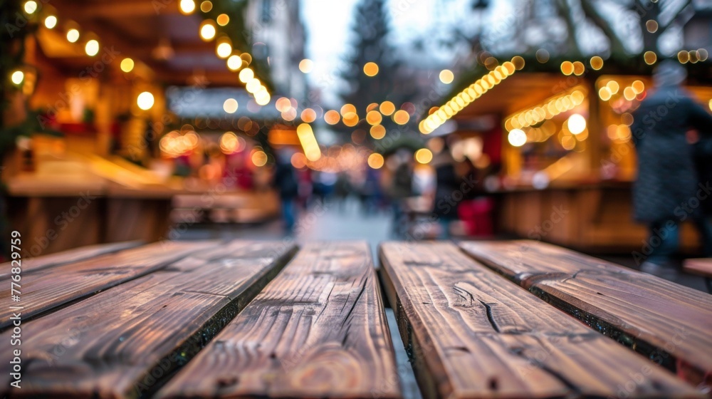 Close-up view of a wooden table with soft ambient light glowing in the background of a Christmas marketplace