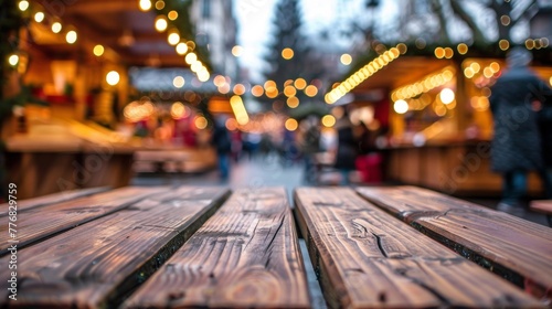 Close-up view of a wooden table with soft ambient light glowing in the background of a Christmas marketplace