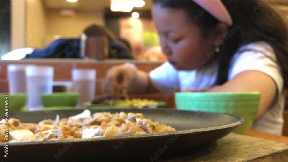 An overweight girl is eating voraciously with her bare hands at a fast food restaurant. Close up An overweight girl is eating voraciously with her bare hands at a fast food restaurant. Close up