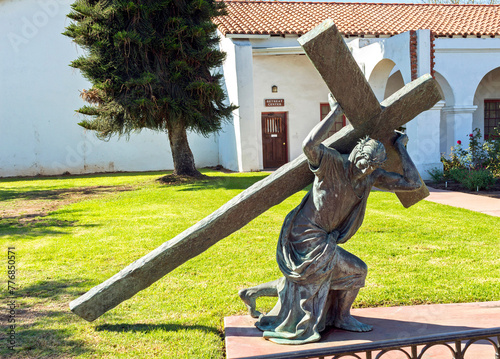 A statue of a Cross in front of the Spanish-Californian Mission San Luis Rey de Francia..Oceanside,California,America photo