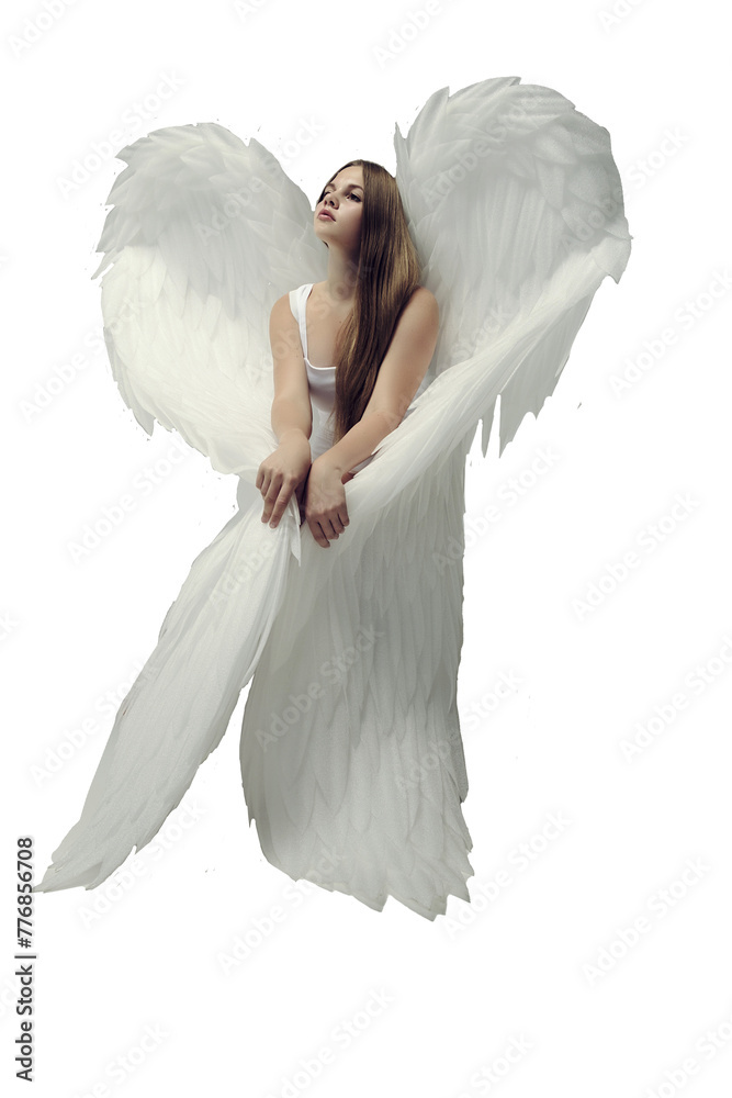 Naklejka premium a romantic angel girl in a white bodysuit with white wings poses sitting in a photo studio