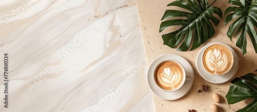 Aesthetic top view of a hot coffee cup on a flat lay marble background, complemented by lush tropical leaves placed elegantly on the side, creating a serene and stylish composition.