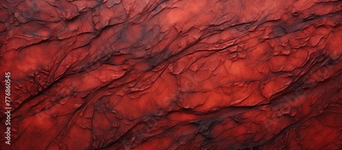 Red rock wall texture up close against a vibrant red sky background, creating a striking natural contrast
