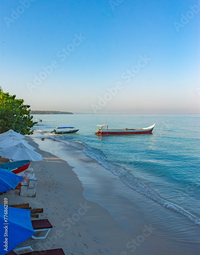 Playa Blanca in Baru, Cartagena, Colombia with anchored boats and lush island backdrop on a clear day photo