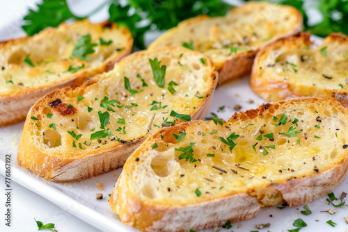 Garlic bread sprinkled with herbs, presented on a white backdrop