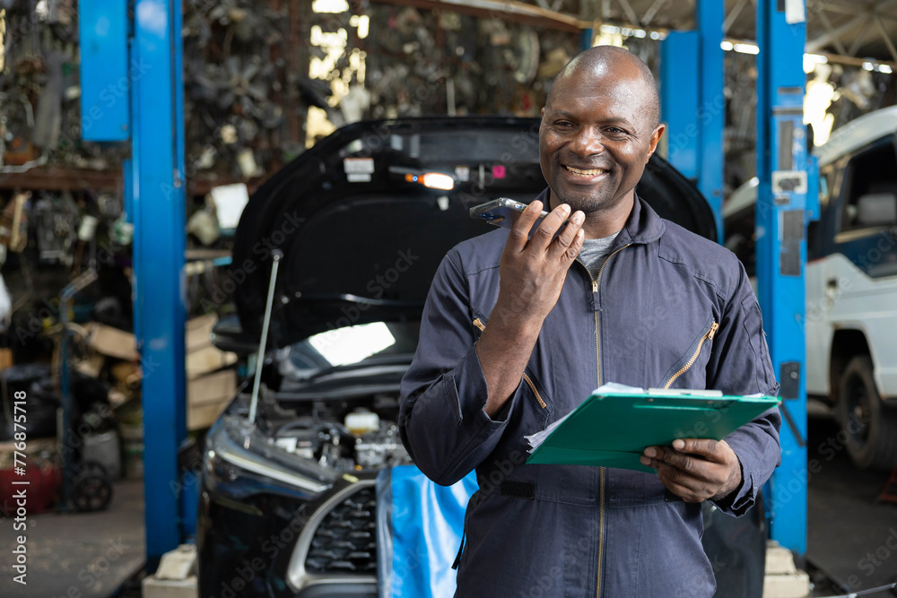 male worker talking on smartphone with customer in garage male worker talking on smartphone with customer in garage