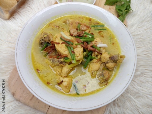 Gulai ayam or chicken curry served in a white bowl. A soupy dish made from chicken cooked with spices and coconut milk. Indonesian traditional cuisine.