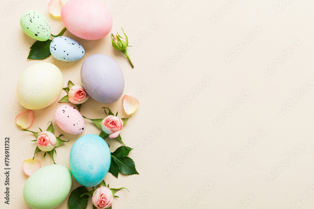 Happy Easter. Easter eggs on colored table with yellow roses. Natural dyed colorful eggs background top view with copy space Happy Easter. Easter eggs on colored table with yellow roses. Natural dyed colorful eggs background top view with copy space