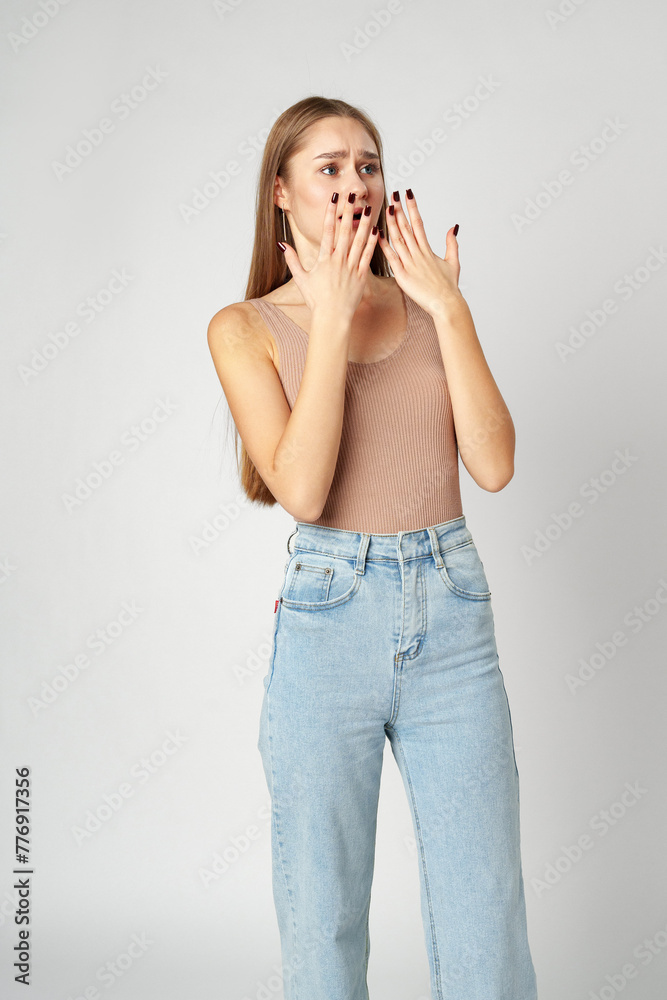 Young woman is in shock or surprise of the news against gray background Young woman is in shock or surprise of the news against gray background