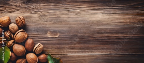 Various nuts and autumn leaves spread out on a rustic wooden table top, creating a natural and seasonal display