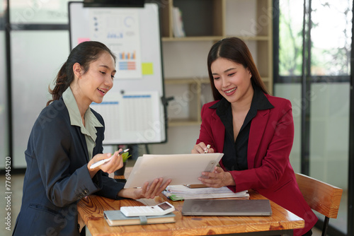 Business team Negotiation, Analysis, Discussion, Asian woman economist and marketer pointing to a financial data sheet to plan investments to prevent risks and losses for the company.
