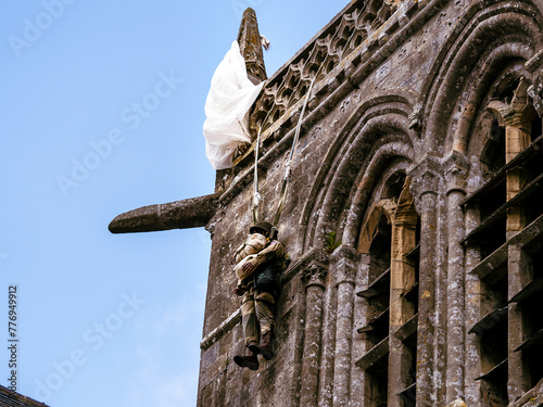 Second world war commemoration at SAINTE MERE L'EGLISE In Normandy, FRANCE. Armed fake soldier with parachute hanged bell tower church