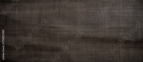 Detail shot of black cloth laid on a dark background, showcasing its texture and color