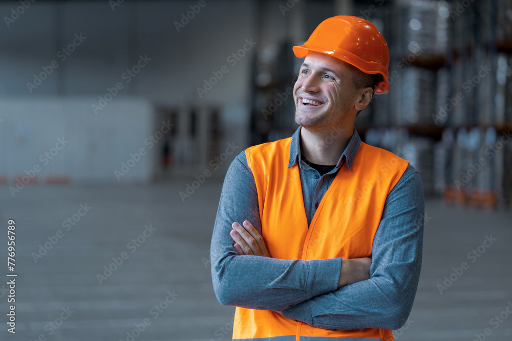 Attractive man, worker, engineer wearing workwear and hard hat, looking away with crossed arms Attractive man, worker, engineer wearing workwear and hard hat, looking away with crossed arms