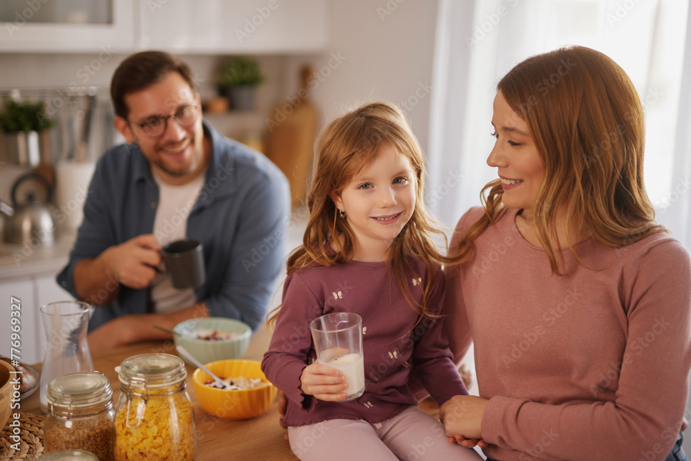Happy family having breakfast at table in kitchen Happy family having breakfast at table in kitchen